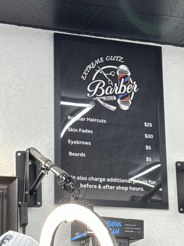 The Extreme Cutz Barber Shop service board listing haircuts, skin fades, eyebrows and beards