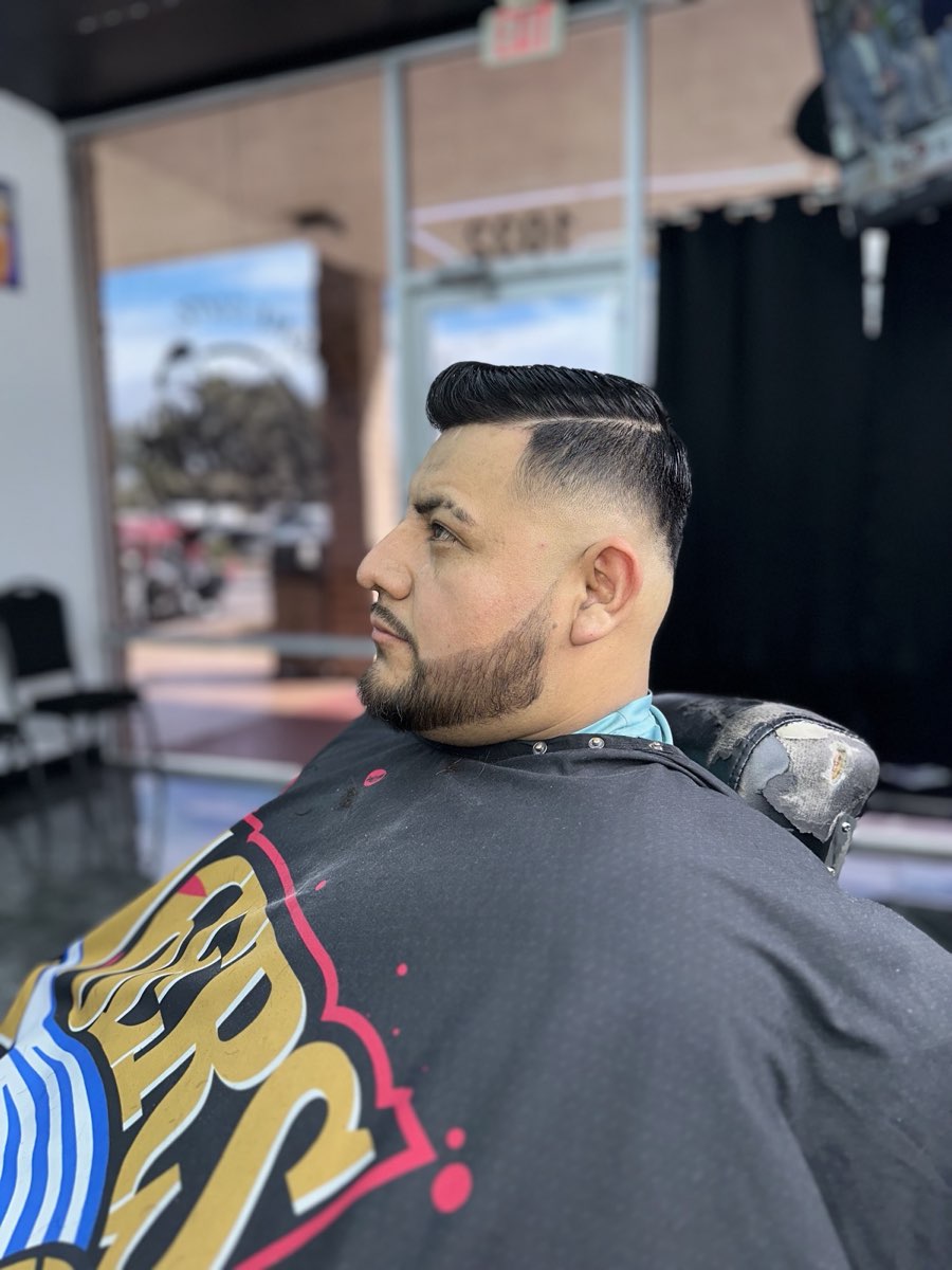 Clean pompadour with a skin fade and shaped beard cut at Extreme Cutz Barbershop